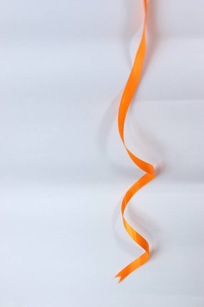 Ruban de satin orange bouclé couleur arc isolé sur fond blanc
.  - Photo, image