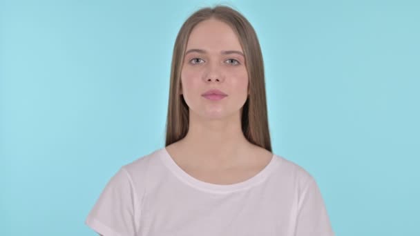 Stop Gesture przez piękną młodą kobietę, niebieskie tło - Materiał filmowy, wideo