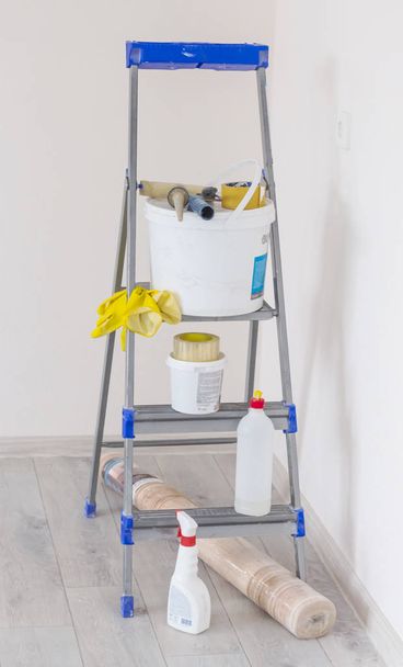 a stepladder with paint cans and tools in a bright renovated corner of the room - Fotoğraf, Görsel