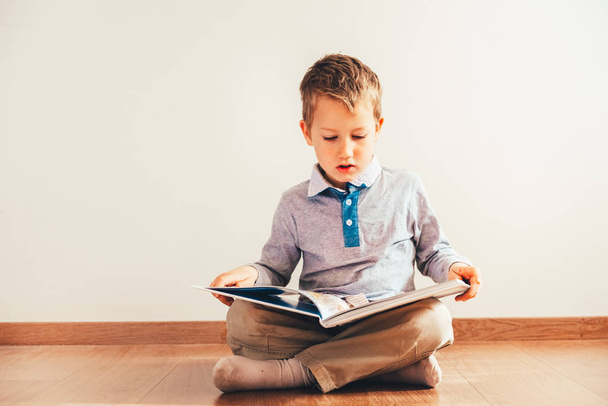 Portrait of boy interested in reading a book. - Zdjęcie, obraz