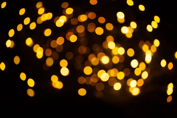 Golden sparkles raster festive background. Bokeh lights with bright shiny effect illustration. Overlapping glowing and twinkling spots decorative backdrop. Abstract glittering circles. - Fotografie, Obrázek