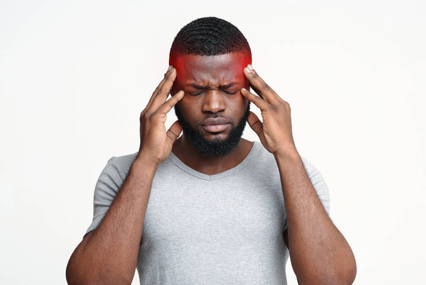 Black guy having migraine, touching his temples - Фото, зображення