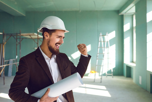 Builder foreman rejoices in a successful project at a construction - Fotoğraf, Görsel