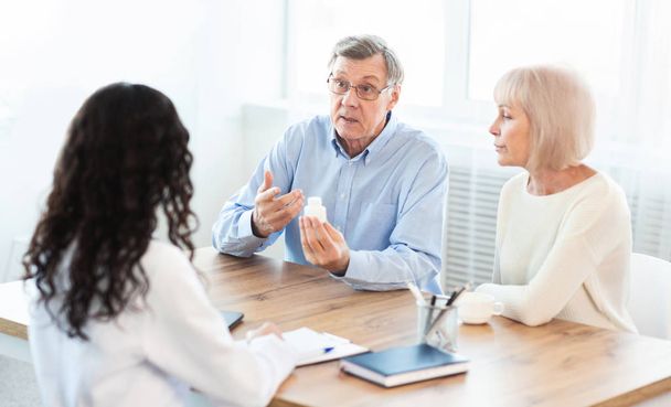 Mature couple asking doctor how to use pill - Photo, Image