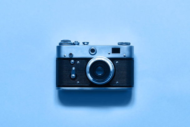 Flatlay vintage retro filmikamera sinisellä taustalla. Kopioi tilaa, ylhäältä. Minimalistinen käsite. Vuoden väri 2020 Classic Blue pehmentänyt
 - Valokuva, kuva