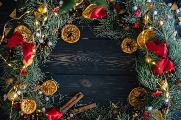 Handmade Christmas wreath on wooden background flat lay. - Foto, imagen