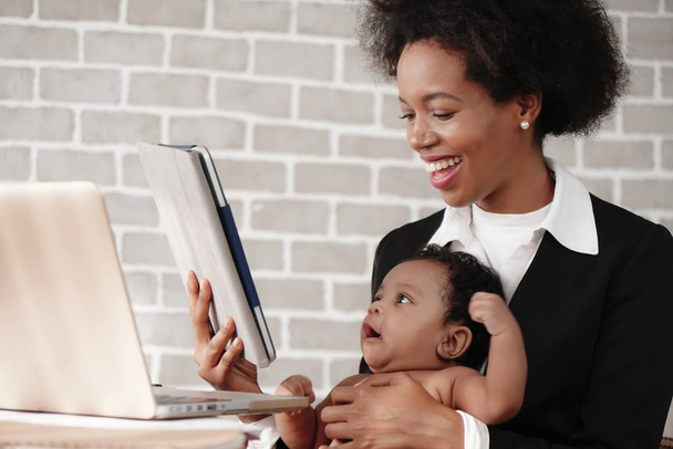 african american mother holding her baby boy on hands while work - Φωτογραφία, εικόνα