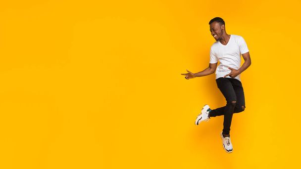 Guy Pointing Fingers Aside Having Fun Over Yellow Background, Panorama - Foto, afbeelding