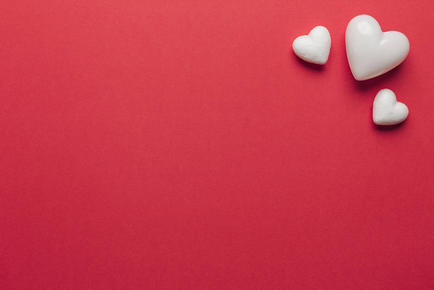 Stock photo of white hearts on a red background with space for text - Zdjęcie, obraz