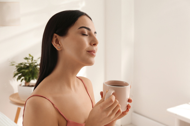 Женщина с чашкой чая в спальне. Ленивое утро
 - Фото, изображение