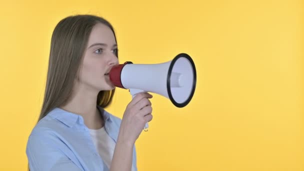 Mooie vrouw kondigt aan op luidspreker, gele achtergrond - Video