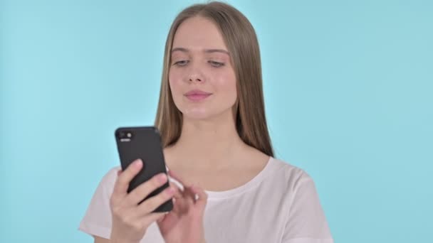 Beautiful Young Woman Talking on Smartphone , Blue Background - Séquence, vidéo