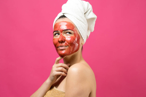 Πορτραίτο ομορφιάς γυναίκας με λευκή πετσέτα στο κεφάλι με χρυσή θρεπτική μάσκα στο πρόσωπο. Καθαρισμός δέρματος eco οργανικό καλλυντικό spa χαλαρώστε έννοια.  - Φωτογραφία, εικόνα