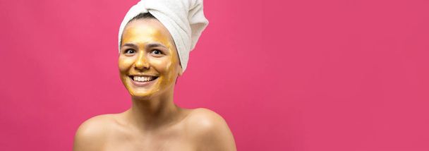 Schoonheidsportret van vrouw in witte handdoek op hoofd met gouden voedende masker op het gezicht. Huidverzorging eco biologische cosmetische spa ontspannen concept. - Foto, afbeelding