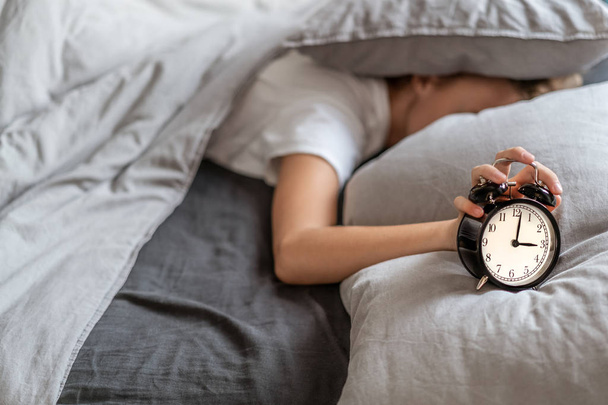 Femme avec insomnie couchée au lit avec sa tête sous son oreiller essayant de dormir
. - Photo, image