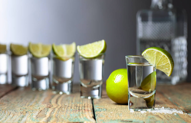 Tequila with  salt and lime on a old wooden background. - Zdjęcie, obraz
