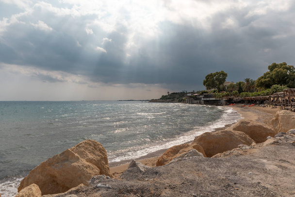 Středozemní moře na severním Kypru. Letní pobřeží s průsvitnými modrými slunečními paprsky v mracích. Pobřeží - Fotografie, Obrázek