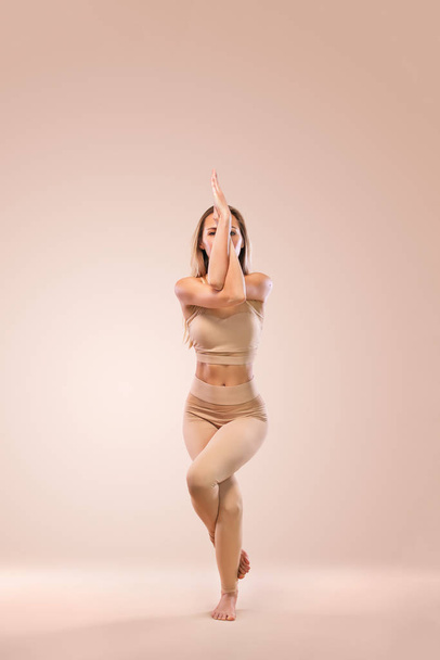 Indoor Yoga Classes. Sports recreation. Beautiful young woman in asana pose. Individual sports. Nude sportswear. - Фото, зображення