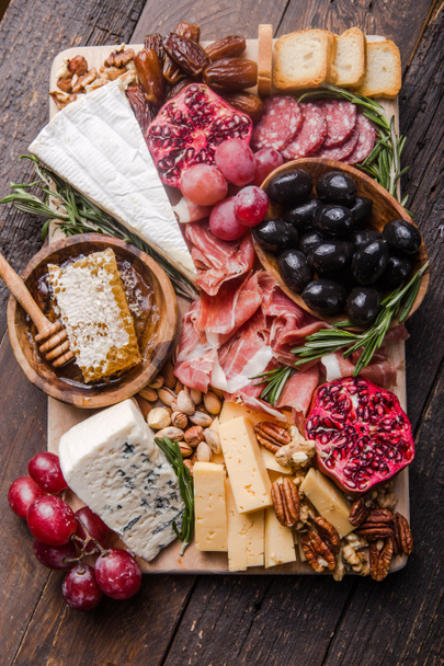 Традиционная итальянская антипастовская тарелка. Ассорти сыров на дереве
  - Фото, изображение