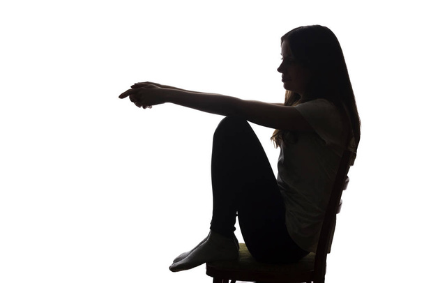 jong mooi meisje in meditatie zit op een stoel - silhouet - Foto, afbeelding