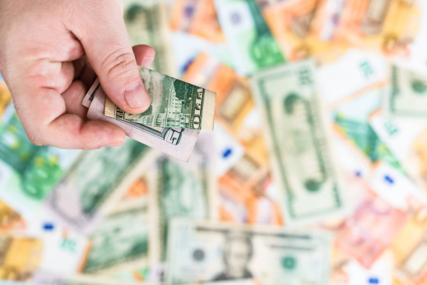Hand giving money like bribe or tips isolated on banknotes backg - Φωτογραφία, εικόνα