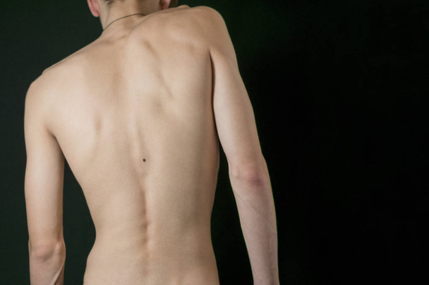 A fragment of a young man's body on a dark background - Zdjęcie, obraz