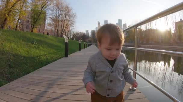 Child boy runs on a wooden platform - Séquence, vidéo