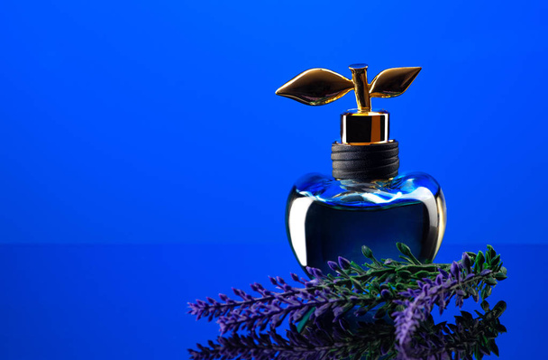 香水ショットオン青の背景クローズアップ - 写真・画像