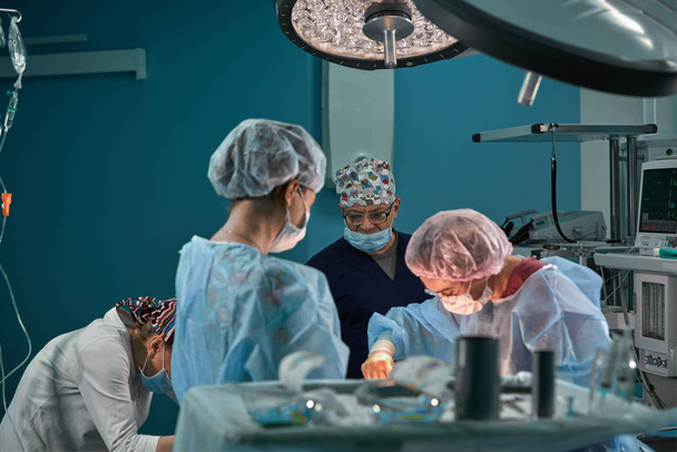 Skupina chirurgů na operačním sále. Lékařský tým provádějící operaci na operačním sále. - Fotografie, Obrázek