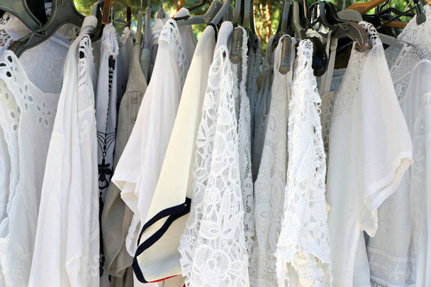 Witte kanten blouses op hangers.  - Foto, afbeelding