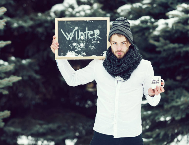 handsome man with cup and blackboard in winter outdoor - Photo, Image