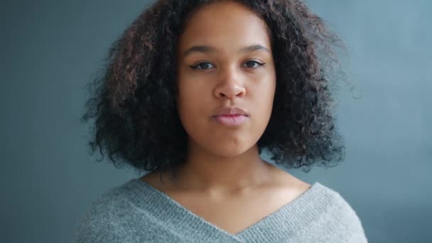 Portrait of attractive Afro-American girl looking at camera with serious face - Materiał filmowy, wideo