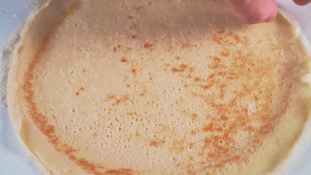 A man puts a freshly baked pancake in a corner and puts it in the center of the plate. Lush fresh quick baking - Footage, Video