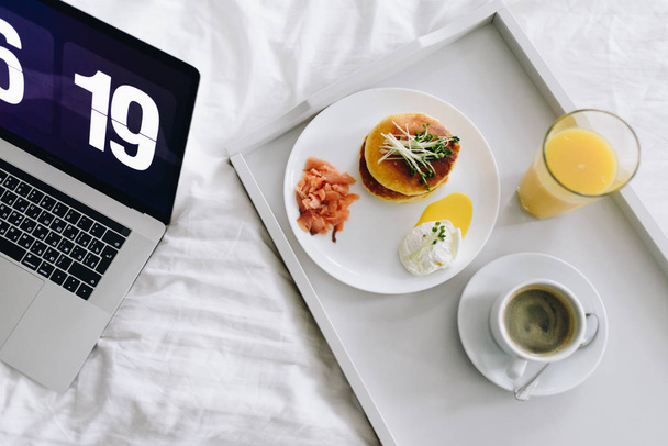 Πολύ νωρίς το πρωί πρωινό με τηγανίτες, σολομό, αυγό, χυμό πορτοκαλιού και καφέ - Φωτογραφία, εικόνα