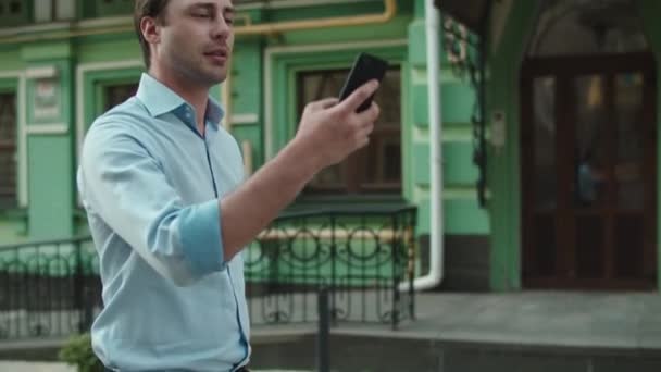 Closeup businessman walking with phone at street. Man talking by video call - Metraje, vídeo