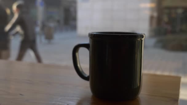 oldalnézetben fekete csésze kávé egy talbe egy kávézóban - Felvétel, videó