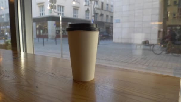 meeneemkoffie in een café met uitzicht op de stad - Video