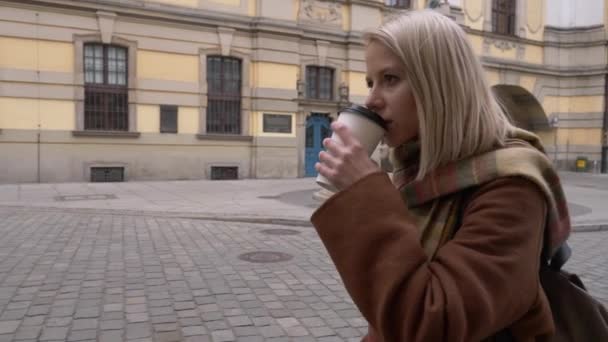 Young woman drink a coffee cup and sitting on bench on the city street - Imágenes, Vídeo