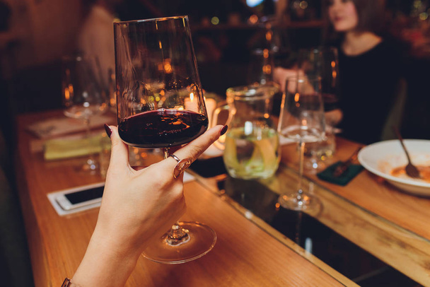 female hand holding glass of red wine. - Foto, Imagem