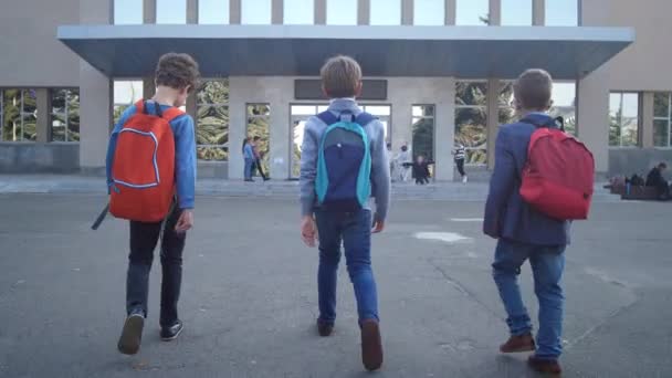 Trois écoliers marchant jusqu'aux portes de l'école
 - Séquence, vidéo