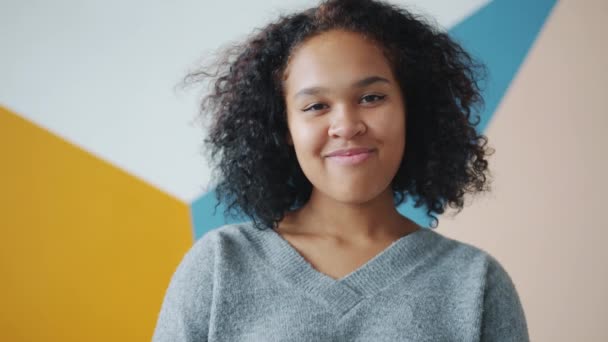 Zoom-out portret van een goed uitziende Afro-Amerikaanse dame op kleurrijke achtergrond - Video