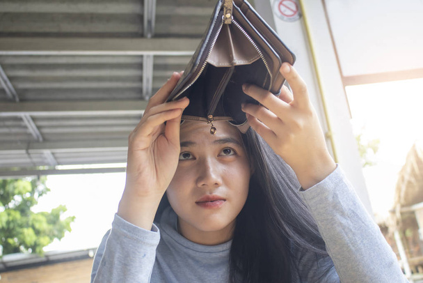 szegény ázsiai nő nyitott üres táska keres pénzt, amelynek probléma - Fotó, kép