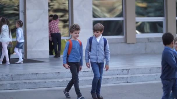 Preteen schoolboys talking while leaving school - Filmmaterial, Video