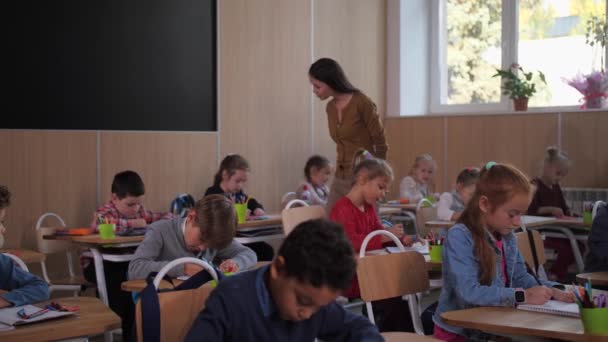 Χαμογελαστή δασκάλα στην τάξη σχεδίου στο σχολείο - Πλάνα, βίντεο