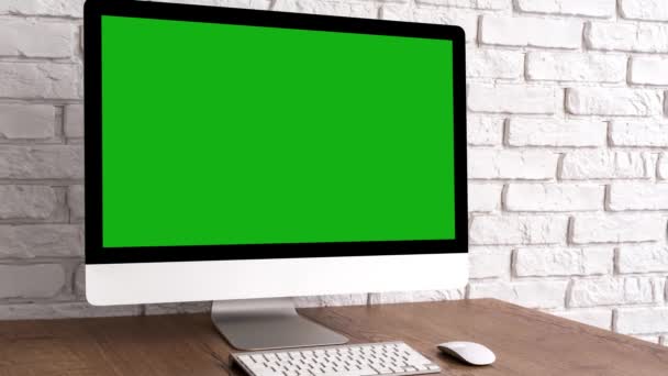 キーボードとマウスを木製のテーブルの上に緑色の画面のコンピュータのデスクトップをモックアップします。クロマキーで職場のコンセプト. - 映像、動画