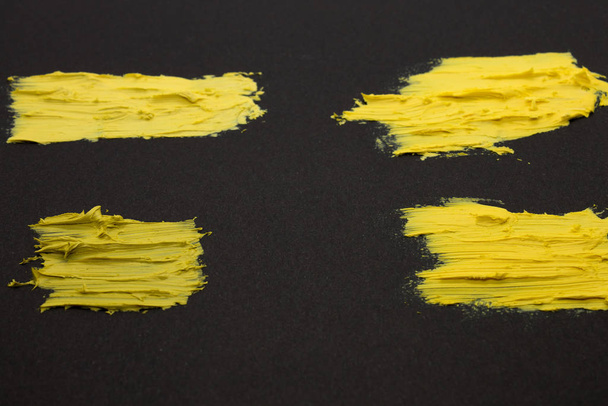 Esta é uma fotografia de amostras de batom amarelo isoladas em um fundo preto
 - Foto, Imagem