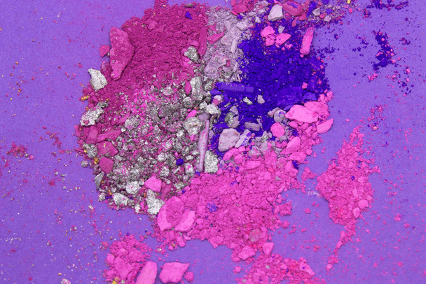 Це фотографія рожевого, пурпурового, синього і срібного порошку, ізольованого на пурпуровому тлі. - Фото, зображення