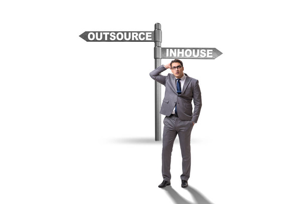 Businessman at crossroads deciding between outsourcing and inhou - Photo, Image