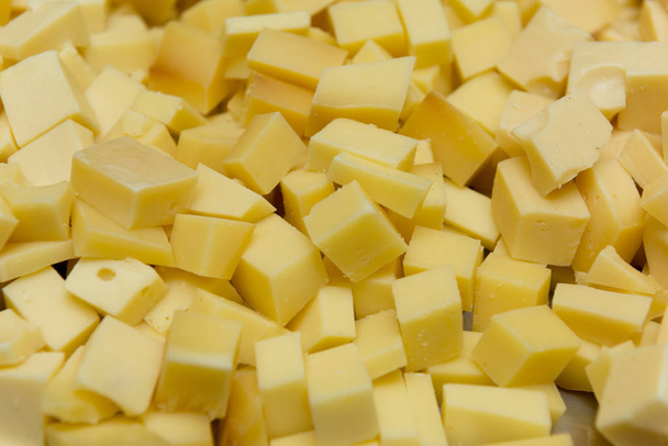 Sluiten van blokjes kaas om op het feest geserveerd te worden. Kaas op smaak gebracht met oregano, zout en olijfolie. Heerlijk om van te genieten en vergezeld van bier. Selectieve focus. - Foto, afbeelding