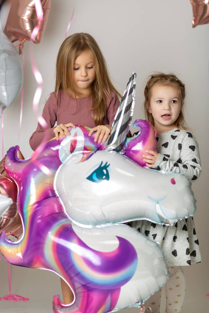 fun birthday with pretty little girl. Festive party with a unicorn - Zdjęcie, obraz